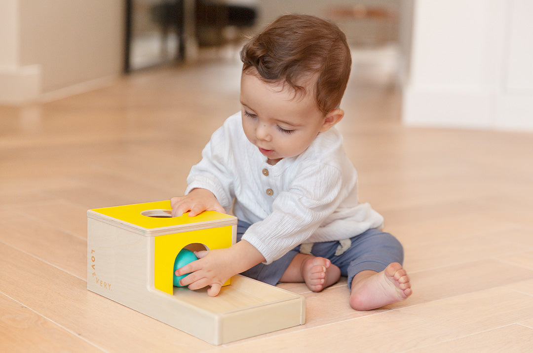 child trying to fit colorful stacking rings